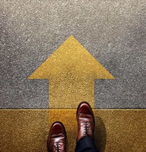 Standing at yellow Arrow on the road, Determination, direction, motivation, Start and Growth Mindset to Move Step Forward. Top View